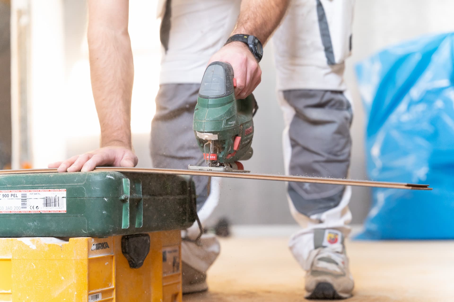Handwerker beim präzisen Zuschnitt eines Bodenpaneels